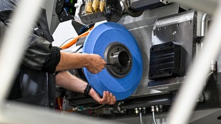 Ein Arbeiter steht an einer Industriemaschine - IHK Pfalz will gegen Fachkräftemangel vorgehen