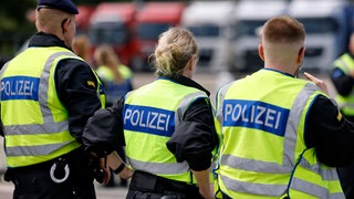 Polizisten stehen während einer Kontrolle auf einem Rastplatz. Am Wochenende stoppte die Polizei nach einer Schlägerei FCK-Fans auf dem Weg zum Spiel nach Berlin. 