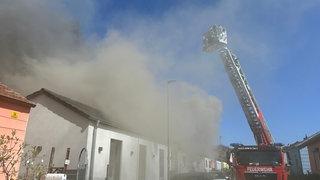 Feuerwehr mit Drehleiter über einem verqualmten Haus - Haus am Eselsbach in Kaiserslautern steht in Flammen