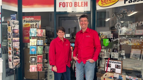 Die beiden Fotografen stehen vor ihrem Laden in der Innenstadt von Kaiserslautern. 