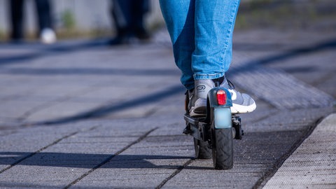 Eine Person fährt auf einem E-Scooter.