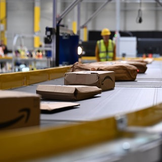 Pakete auf einem Förderband. In Zweibrücken will Amazon eine Halle am Flughafen zu einem Logistikzentrum umbauen. 