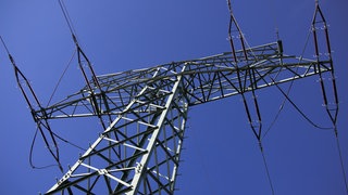 In mehrere Gemeinden (Otterberg-Otterbach, Weilerbach) im Kreis Kaiserslautern herrscht seit dem Vormittag Stromausfall. (Strommast vor blauem Himmel)