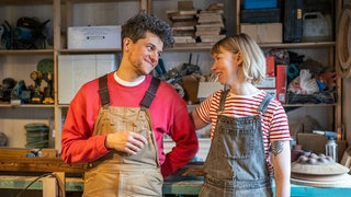 Die Volkshochschulen in der Westpfalz starten in das neue Semesterprogramm, unter anderem mit Flirtkursen. Ein Pärchen beim Flirten in einer Schreinerei.