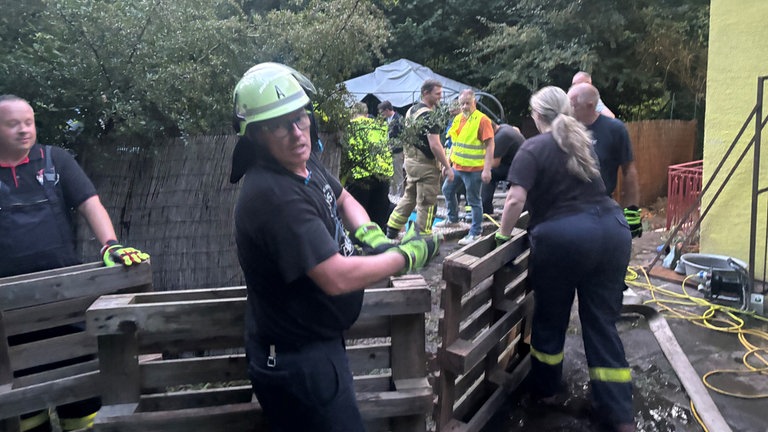 Eilig werden Paletten zum Pool gebracht, um schnelle Hilfe für das Pferd im Pool bei Trippstadt zu leisten. 