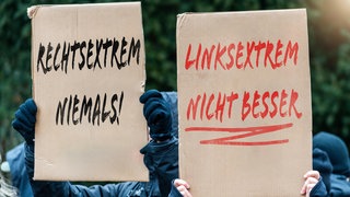 Demonstranten mit Schildern gegen Rechts- und Linksextremismus (Symbolbild)