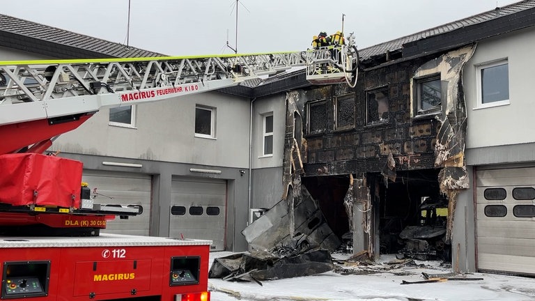 Brand in Kirchheimbolanden: Die zerstörte DRK-Halle nahe dem Krankenhaus mit ausgebrannten Rettungfahrzeugen.