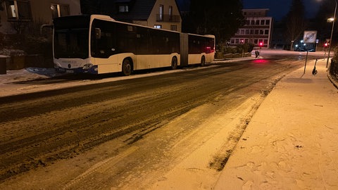 Ein Bus steht am Straßenrand auf einer winterlichen Straße in Kaiserslautern