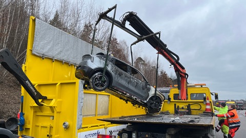 Eines der E-Autos wird in eine Elektromulde verladen.