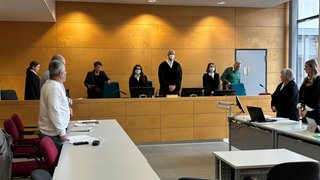 Prozessauftakt am Landgericht Kaiserslautern: Ein Mann soll in der Afa Kusel zwei Mitbewohner mit einem Messer schwer verletzt haben. Im Vordergrund sein Dolmetscher (weißer Pullover).