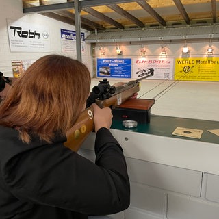 Eine junge Frau zielt mit einem Luftgewehr auf eine Zielscheibe beim Ostereierschießen in Ramsen