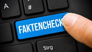 Finger auf Computertaste mit Aufschrift Faktencheck