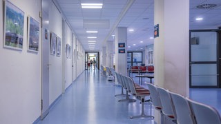 Langer Krankenhausflur mit Stühlen (Symbolbild). Das Westpfalz-Klinikum sichert Spuren nach Gewalt.