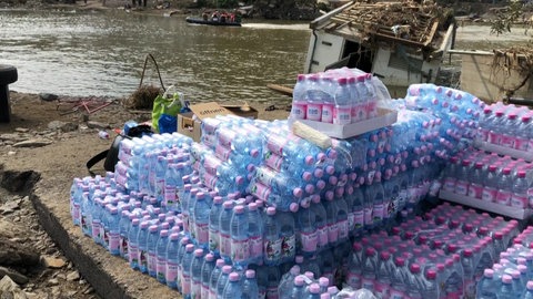 Eine Palette mit Trinkwasser steht neben dem verwüsteten Ahrufer in Rech