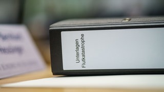 Ein Aktenordner mit der Aufschrift "Unterlagen Flutkatastrophe" liegt im rheinland-pfälzischen Landtag bei der Sitzung des Untersuchungsausschusses zur Flutkatastrophe im Ahrtal.
