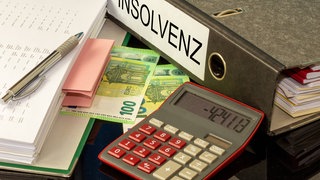 Taschenrechner, Geld und Insolvenzordner - die Zahl der Firmeninsolvenzen im Westerwaldkreis ist landesweit die höchste.