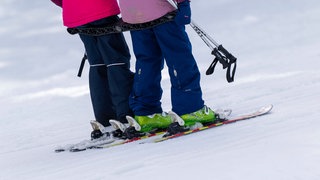 Kinder auf einem Schlepplift im Skigebiet