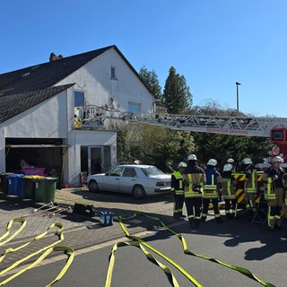 Die Feuerwehr steht vor einem Einfamilienhaus in Simmern im Hunsrück. Bei dem Brand des Hauses ist die Bewohnerin verstorben, laut Polizei vermutlich an einer Rauchgasvergiftung.