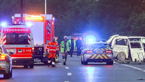 Polizei- und Feuerwehrwagen stehen auf der Autobahn 48 nahe Koblenz an einer Unfallstelle. Dort ist ein Kleinlaster von der Straße abgekommen und drei Menschen starben.