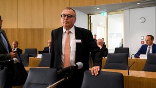 Der ehemalige Landrat des Kreises Ahrweiler Jürgen Pföhler steht in einem Raum an einem Stuhl. Gegen Pföhler wird vermutlich eine Disziplinaranklage wegen Versäumnissen bei der Flutkatastrophe im Ahrtal 2021 erhoben.
