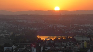 Das Symbolbild zeigt einen Sonnenuntergang über Koblenz. Die Stadt spürt schon heute die Auswirkungen des Klimawandels. Trotzdem passiert beim Klimaschutz noch zu wenig, sagen drei Studenten.