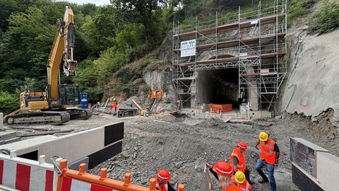 Ein Bagger auf Ketten arbeitet gerade an einem Tunnel der Ahrtalbahn.