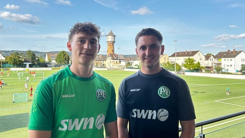 Die beiden Mittelfeldspieler des FV Engers Marcel Stieffenhofer und Goran Naric stehen auf der Tribüne des Stadions am Wasserturm in Neuwied-Engers. Sie freuen sich schon auf ihr Spiel gegen Eintracht Frankfurt.