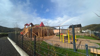 Das neue Klettergrüst in Form einer Burg vor einem Regenbogen.