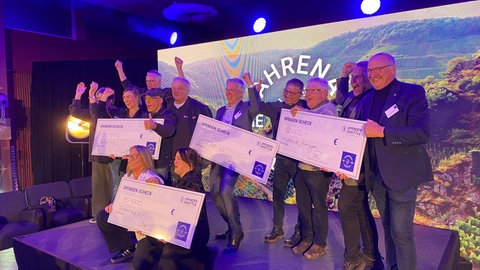 Gewinnervereine mit ihren großen Schecks freuen sich: Das Spendenshuttle im Ahrtal hat Geld an zehn Projekte gegeben bei der Ahrena der Ideen.