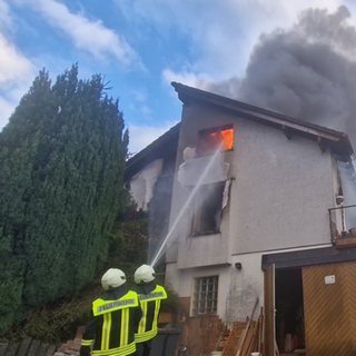 Bei einem Brand in Bad Ems im Rhein-Lahn-Kreis löscht die Feuerwehr das Feuer in einem Einfamilienhaus.