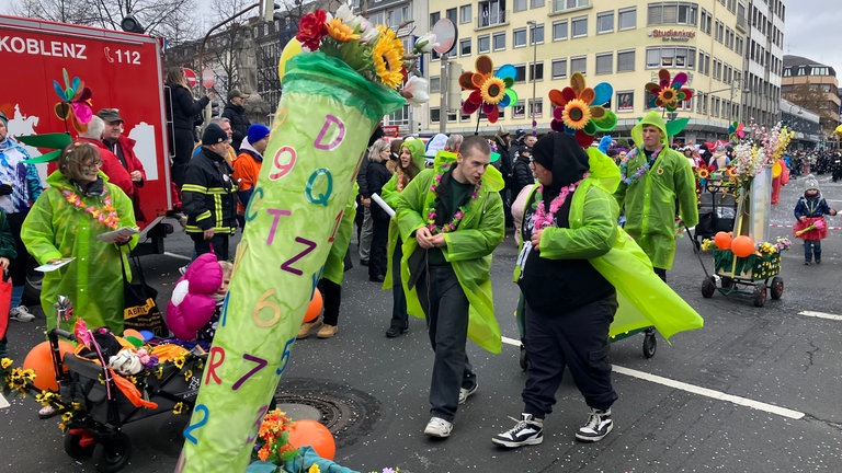 Eine als Gaertner verkleidete Fußgruppe läuft im Koblenzer Rosenmontagsumzug 2026 mit. 