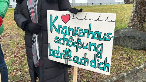 Schild mit der Aufschrift "Krankenhausschließung betrifft auch dich"