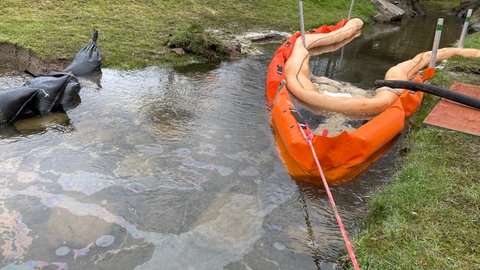 Eine Ölsperre im Simmerbach im Hunsrück soll verhindern, dass sich der Diesel im Wasser ausbreitet.