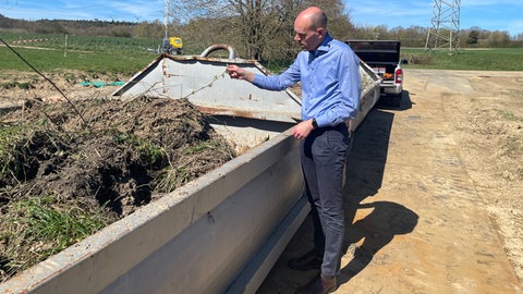 Containerweise müssen belastete Erde und Gras abtransportiert werden. Der Landrat des Rhein-Hunsrück-Kreises Volker Boch (parteilos) inspiziert die Lage.