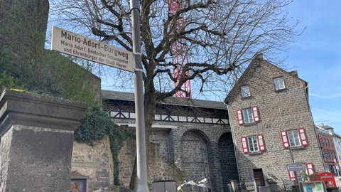 Straßenschild des Mario-Adorf-Burgwegs. Mayen hat den Aufgang zur Burg nach Mario Adorf benannt.