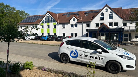 Auto der Lebenshilfe vor dem sanierten und neu eröffneten Lebenshilfehaus in Sinzig. Fast fünf Jahre nach der Flutkatastrophe im Ahrtal wird das Lebenshilfehaus in Sinzig jetzt offiziell neu eröffnet. 