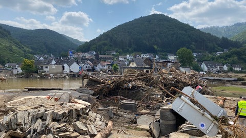 Wenige Tage nach der Flutkatastrophe im Ahrtal staute sich wie hier in Rech der Unrat. Deutlich erkennbar sind auch die Zerstörungen an den Häusern, die in vielen Fällen auch Winzer trafen.