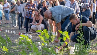 Das Archivfoto aus dem Jahr 2022 zeigt Menschen, die in Erinnerung an die Toten der Ahrflut Kerzen aufstellen und anzünden.