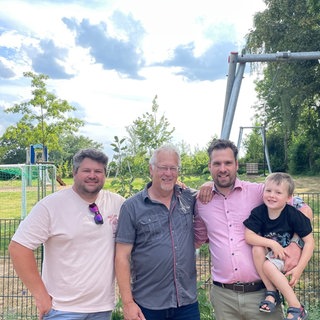 Nicolas Ahrend, Michael Gruner und Philipp Hergesell mit Sohn Paul (von links) am Mehrgenerationenplatz.