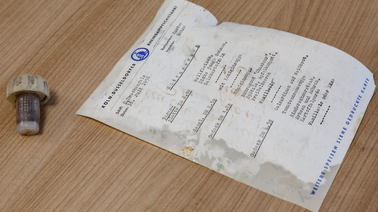 Nahaufnahme der getippten Preisliste für Essen und Getränke auf einem KD-Ausflugsschiff. Der Zettel gehört zu der Flaschenpost, die bei Oberwesel gefunden wurde. 