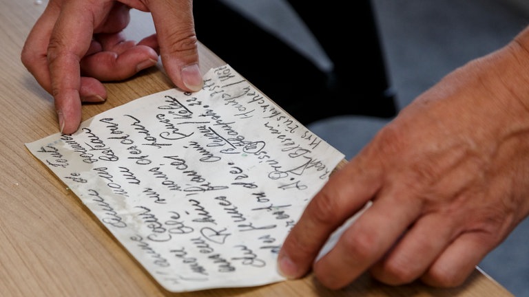 Der handgeschriebene Text aus der Flaschenpost bei Oberwesel ausgebreitet auf einem Tisch. 