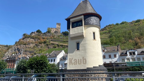 Der Pegelturm in Kaub und dahinter die Stadt Kaub am Rhein.