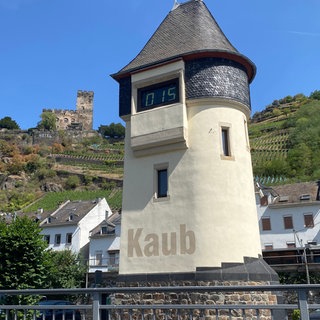 Der Pegelturm in Kaub und dahinter die Stadt Kaub am Rhein.