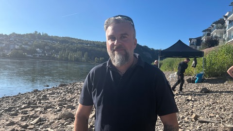 Der technische Leiter des Kampfmittelräumdienstes Rheinland-Pfalz Sven Rasehorn steht am Rheinufer.