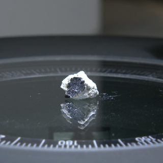 Ein Meteorit auf einer Platte unter einem Mikroskop