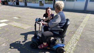 SWR-Reporterin Nancy Lau (links) unterhält sich mit einer Bürgerin aus Ludwigshafen-Gartenstadt.