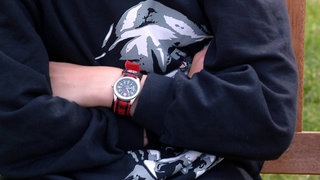 Jugendlicher schmollt - Symbolbild für 16-Jähriger will sein Zimmer nicht aufräumen und alarmiert die Polizei