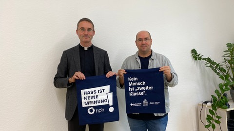 Auf Stofftaschen wird für das Positionspapier der christlichen Kirchen in Ludwigshafen geworben.