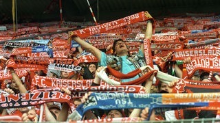 Fans bejubeln die Deutsche Meisterschaft des 1. FC Kaiserslautern 1998. Darunter auch ein befreundeter Fan von 1860 München.