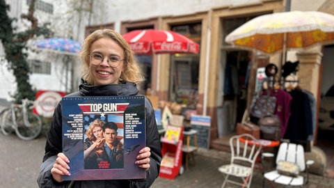 SWR-Reporterin Theresa Lienen hält eine Schallplatte mit der Filmmusik von Top Gun hoch.